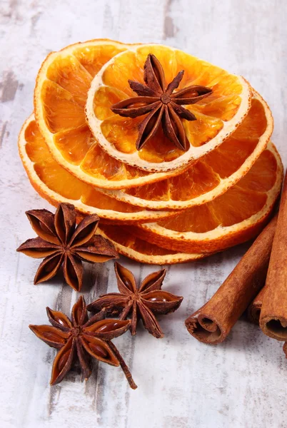 Segmenten van uitgedroogde citroen-, sinaasappel- en specerijen op oude houten achtergrond — Stockfoto