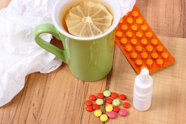 Pills and nose drops for colds, handkerchiefs and hot tea with lemon — Stock Photo, Image