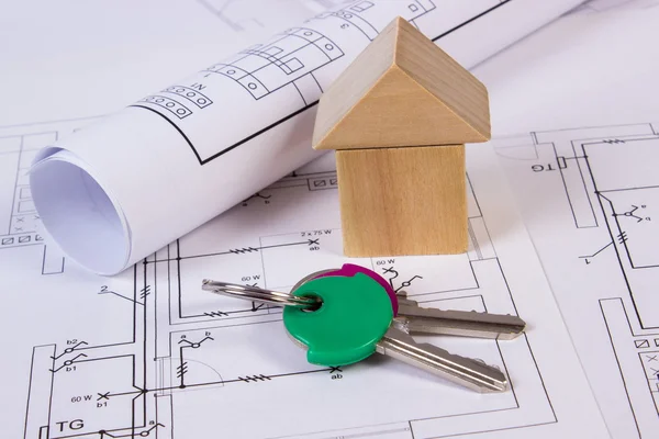 Maison de blocs de bois, rouleaux de diagrammes et de clés sur le dessin de construction de la maison — Photo