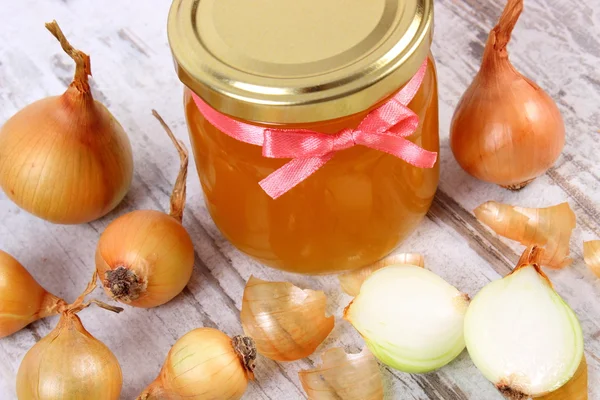 Frischer Bio-Honig im Glas und Zwiebeln auf Holzgrund, gesunde Ernährung und Stärkung der Immunität — Stockfoto