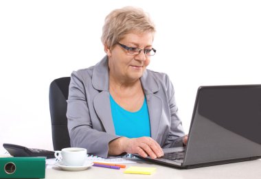 Ofis, iş kavramı onun masasında laptop ile çalışan yaşlı iş kadın