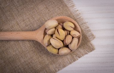 Beyaz ahşap masa, sağlıklı kaşık ile fıstık fındık yemek