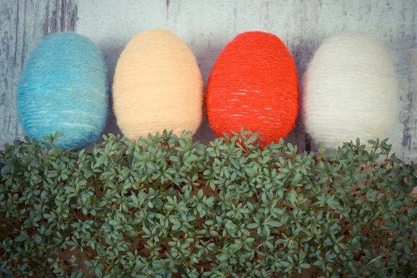 Foto vintage, ovos de Páscoa envolto fio de lã e agrião verde no fundo de madeira, decoração para a Páscoa — Fotografia de Stock