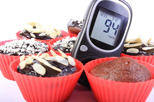 Γλυκόζη μετρητές και σοκολάτα muffins σε κόκκινα φλιτζάνια — Φωτογραφία Αρχείου