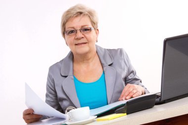 Yaşlı iş kadını ofiste iş kavramı masasında belgeleriyle çalışma