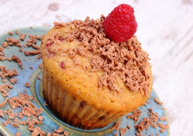 Ahududu ve ahşap zemin, lezzetli tatlı üzerine rendelenmiş çikolata ile pişmiş kek