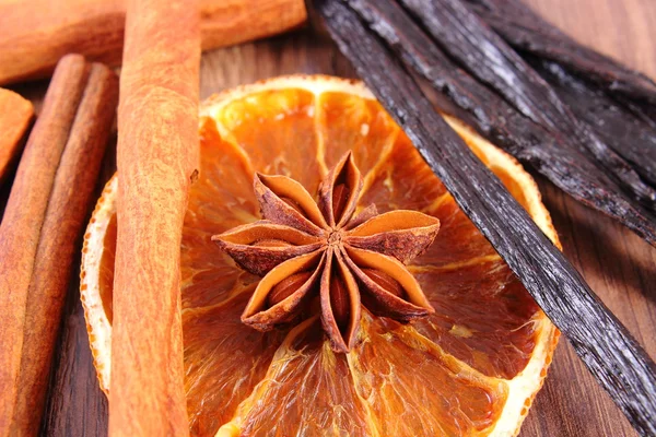 Γλυκάνισο, αρωματική βανίλια, κανέλα και αποξηραμένο πορτοκάλι σε ξύλινη επιφάνεια — Φωτογραφία Αρχείου