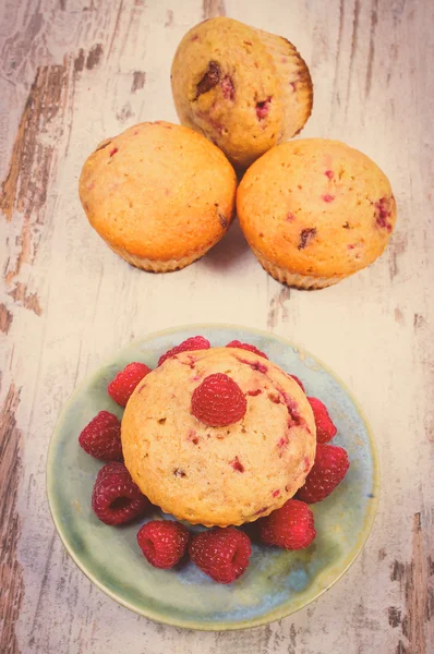 Vintage photo, Fresh baked muffins with raspberries on old wooden background, delicious dessert — Stock Photo, Image