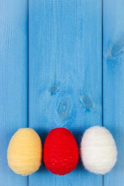 Kopya alanı metin, Paskalya için dekorasyon için mavi ahşap kurullarında yün dize Paskalya yumurta sarılı