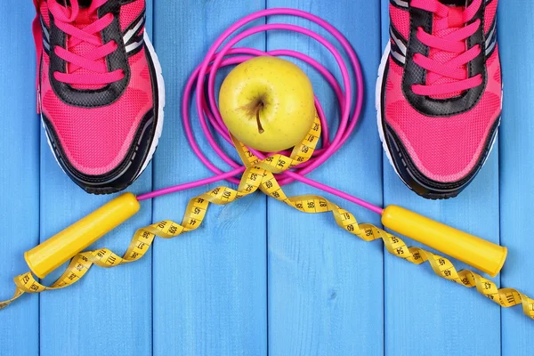 Par de zapatillas deportivas, manzana fresca y accesorios para fitness en tableros azules, espacio de copia para texto — Foto de Stock