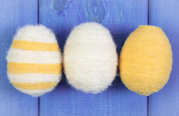 Oeufs de Pâques enveloppés de laine sur des planches en bois bleu, décoration pour Pâques — Photo