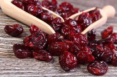 Ahşap masa kaşık ile kırmızı kızılcık yığını