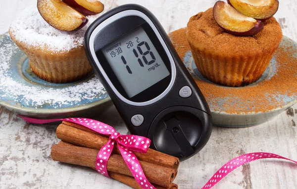 Glucómetro, muffins con ciruelas en polvo azúcar y canela, diabetes y delicioso postre — Foto de Stock