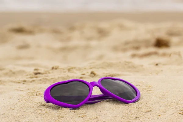 砂の上のハートの形をした紫色のサングラス — ストック写真