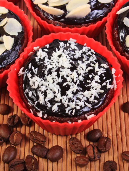 Magdalenas de chocolate con coco desecado y almendras, granos de café —  Fotos de Stock