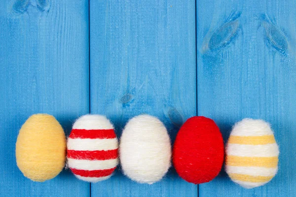 Oeufs de Pâques enveloppés de laine sur des planches en bois bleu, espace de copie pour le texte, décoration pour Pâques — Photo