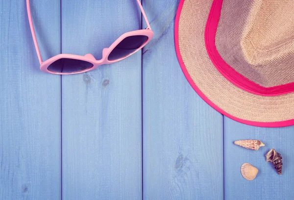 Photo vintage, Lunettes de soleil roses et chapeau de paille sur des planches en bois bleu, accessoires pour l'été — Photo