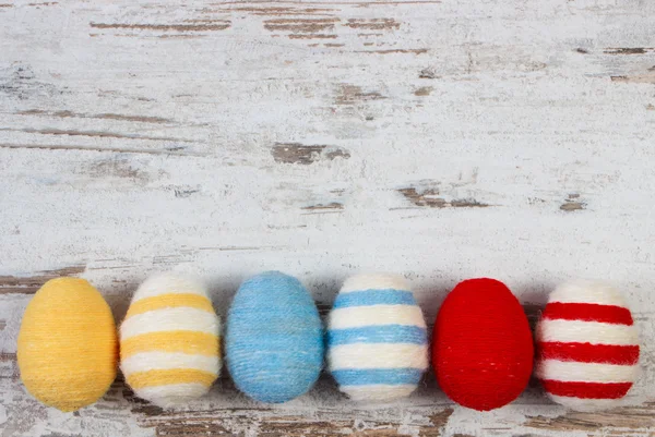 Easter eggs wrapped woolen string on wooden background, copy space for text, decoration for Easter — Stock Photo, Image