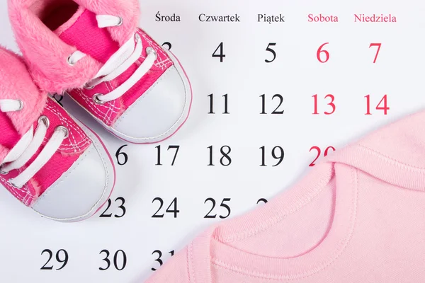 Abbigliamento per neonato sul calendario, in attesa per il bambino — Foto Stock