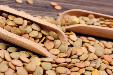 Ahşap zemin üzerine kaşıkla yeşil mercimek yığını