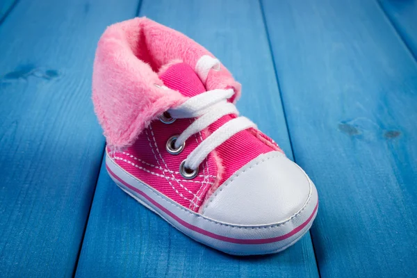 Coppia di scarpe bambino su tavole blu, in attesa per il bambino — Foto Stock