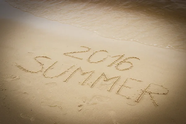 Verano 2016 dibujado sobre arena en la playa junto al mar —  Fotos de Stock