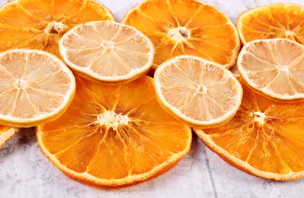 Slices of dried lemon and orange on old wooden background
