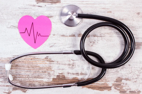 Serce z papieru z linii inwalida i stetoskop na drewniane tła, medycyny i opieki zdrowotnej koncepcja — Zdjęcie stockowe
