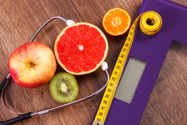 Elektronische Badezimmerwaage, Zentimeter und frisches Obst mit Stethoskop, Schlankheitskur und gesundem Lebensstil — Stockfoto