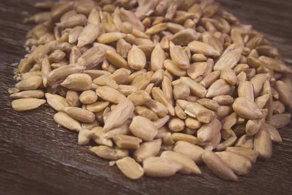 Vintage photo, Heap of sunflower seeds on wooden background — Stockfoto