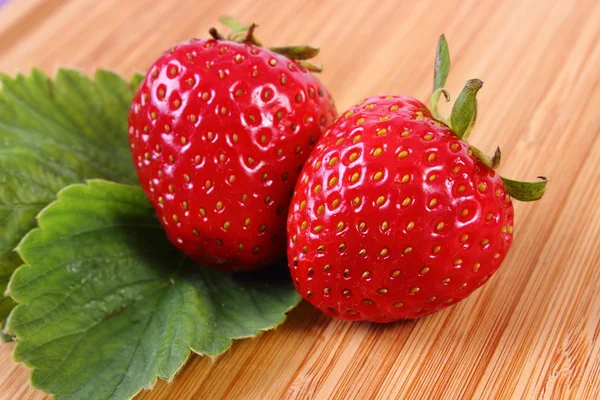 Fraise avec feuilles sur la surface en bois — Photo