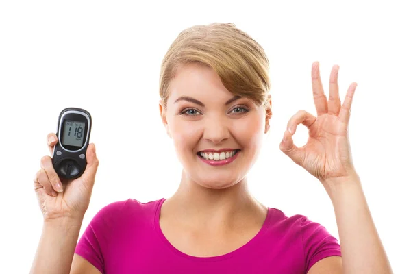 Woman holding glucometer and showing sign ok, checking and measuring sugar level, concept of diabetes — Stockfoto