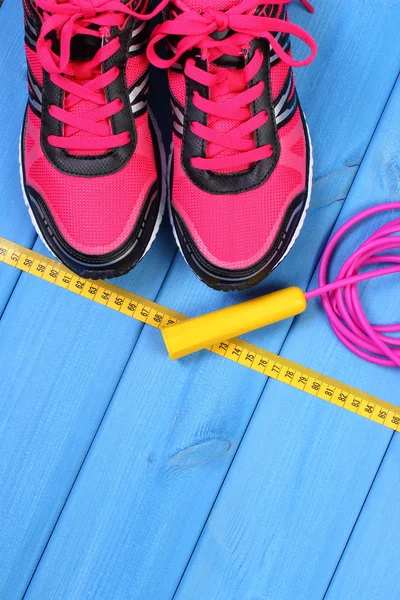 Par de zapatos deportivos de color rosa y accesorios para fitness en tableros azules, espacio de copia para texto — Foto de Stock