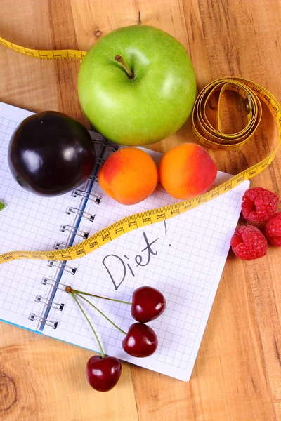 Fruits et centimètre avec carnet, minceur et aliments sains — Photo