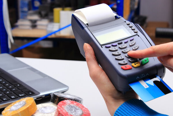 Paying with credit card in an electrical shop, finance concept