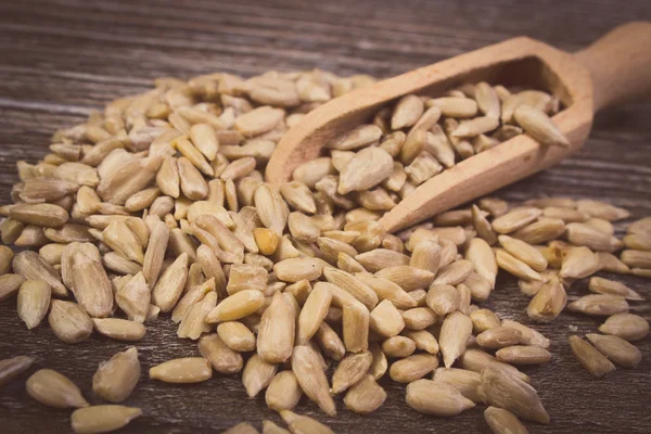 Vintage photo, Sunflower seeds with spoon on wooden background — Stockfoto