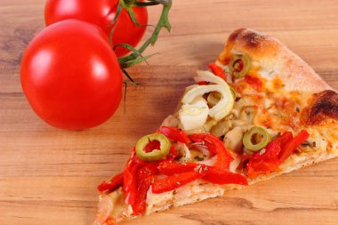 Vejetaryen pizza ve ahşap yüzey üzerinde domates dilim