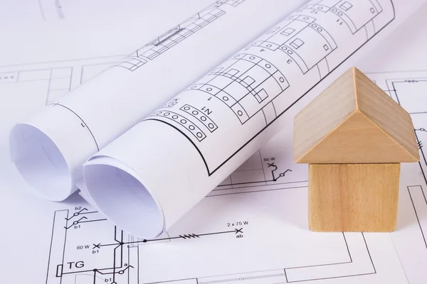 La casa de los bloques de madera y los rollos de los diagramas sobre la construcción el dibujo de la casa — Foto de Stock