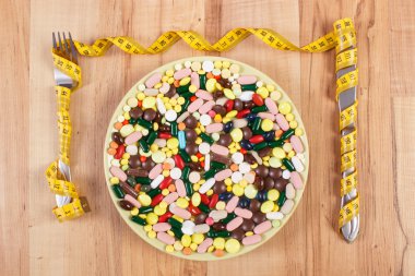 Tablet veya tabak ve çatal bıçak sarılmış santimetre, sağlık ve zayıflama kavramı ile takviyeleri