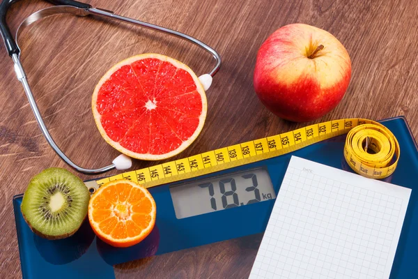 Electronic bathroom scale, centimeter and fresh fruits with stethoscope, slimming and healthy lifestyles — Stock Photo, Image