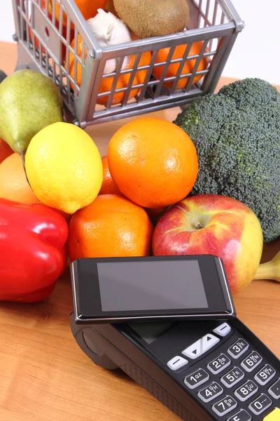 Terminal de pago y teléfono móvil con tecnología NFC, frutas y verduras, pago sin efectivo para compras — Foto de Stock