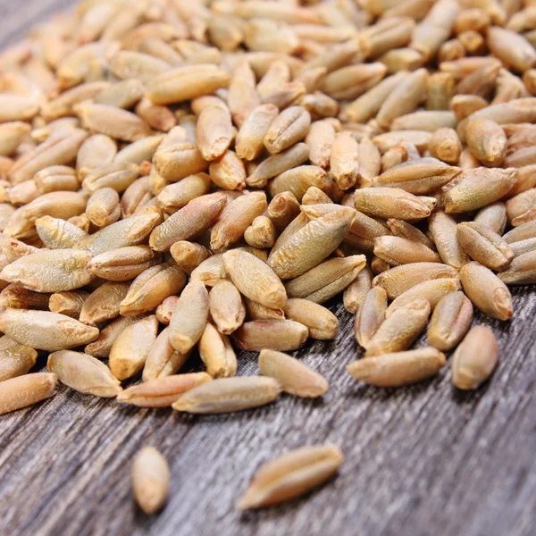 Montón de grano de centeno sobre fondo de madera — Foto de Stock