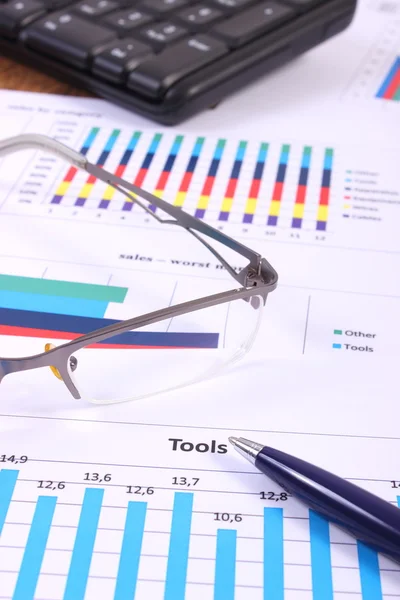 Pióra, okulary i komputera klawiatura na wykresie finansowych, koncepcja biznesowa — Zdjęcie stockowe
