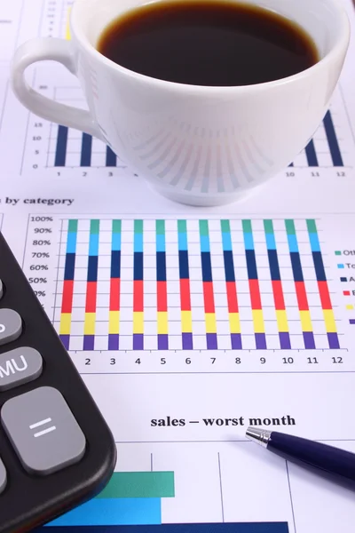 Pluma, calculadora y taza de café en gráfico financiero, concepto de negocio —  Fotos de Stock