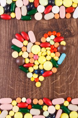 Heart shaped colorful medical pills and capsules, health care concept