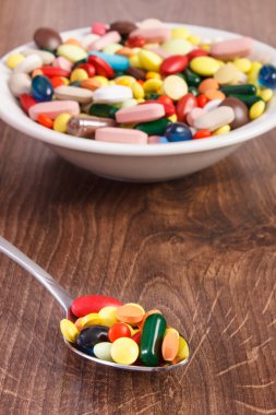 Çay kaşığı ve yığın renkli tıbbi kapsül içinde geçmiş, sağlık kavramı tıbbi ilaçlar