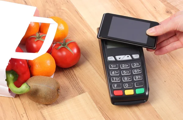 Платіжний термінал і мобільний телефон з Nfc технології, фрукти та овочі, безготівкової оплати за покупками — стокове фото