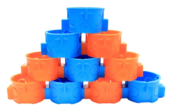Empilement de boîtes électriques bleues et orange. Fond blanc — Photo