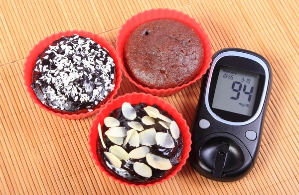 Magdalenas de glucosímetro y chocolate en tazas rojas — Foto de Stock