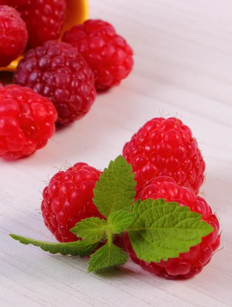 Fresh raspberries and lemon balm on white wooden table, healthy food — Stock Photo, Image